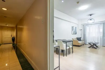 a living room and dining room with a dining table at Forbeswood Heights 1Br with Garden view in Manila