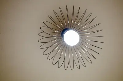 a sunburst mirror hanging on a wall at Forbeswood Heights 1Br with Garden view in Manila