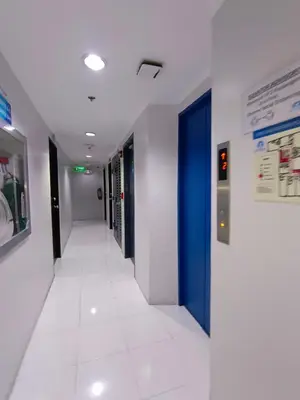 an empty hallway in a hospital with a blue door at City Space in Manila