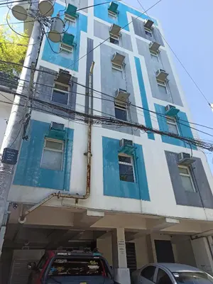 a building with blue windows and a car parked in front at City Space in Manila