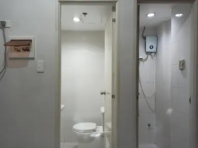 a white bathroom with a toilet and a shower at City Space in Manila