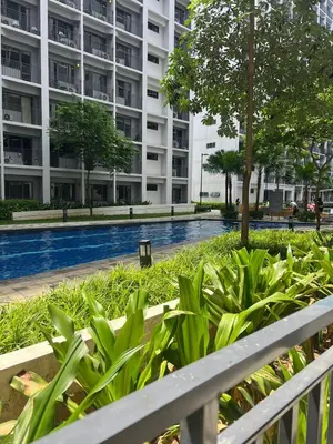 a building with a swimming pool in front of a building at Cozy Vibes near MOA & NAIA AIRPORT with NETFLIX,MINIVIDEOKE,BOARDGAMES-DUXE4 in Manila