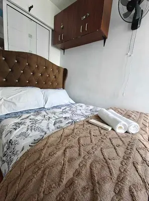 a bed with two white towels on top of it at Serenity Escapes by Aj in Manila