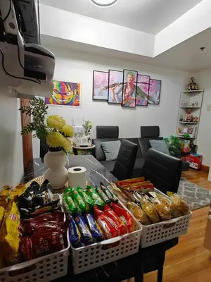 a living room with a table full of food at Serenity Escapes by Aj in Manila