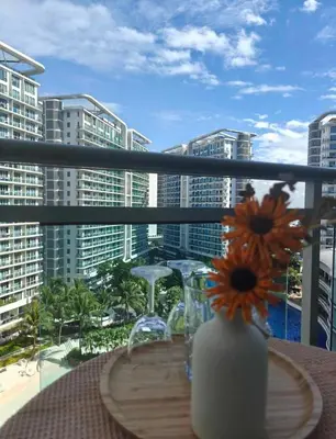 a table with a vase with flowers on a balcony at Serenity Escapes by Aj in Manila