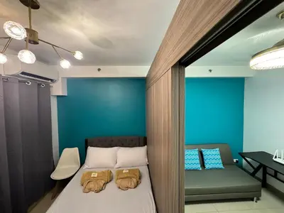 a bedroom with a bed and a blue wall at 726 Shore 2 Residences near SM MOA & IKEA by Prime Stay in Manila