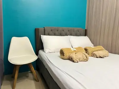 a bed with two blankets and a chair on it at 726 Shore 2 Residences near SM MOA & IKEA by Prime Stay in Manila