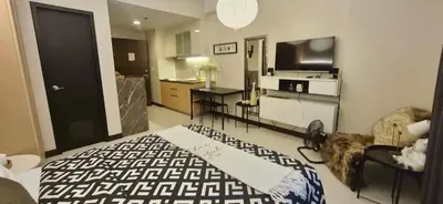 a room with a bed and a kitchen with a television at A&G Condotel at 101newport Near NAIA T3 in Manila