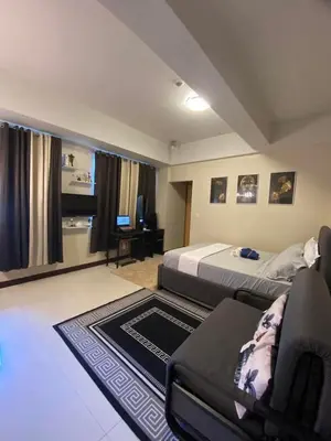 a bedroom with a bed and a chair and a couch at A&G Condotel at 101newport Near NAIA T3 in Manila