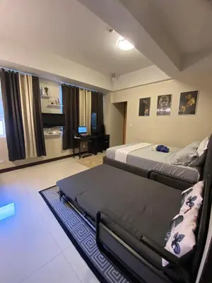 a bedroom with two beds and a living room at A&G Condotel at 101newport Near NAIA T3 in Manila