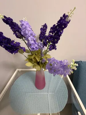 a pink vase with purple flowers sitting on a table at Sea Residences Briella's Staycation in Manila