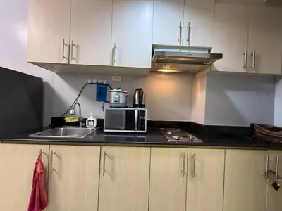 a kitchen with a microwave and a sink at Sea Residences Briella's Staycation in Manila