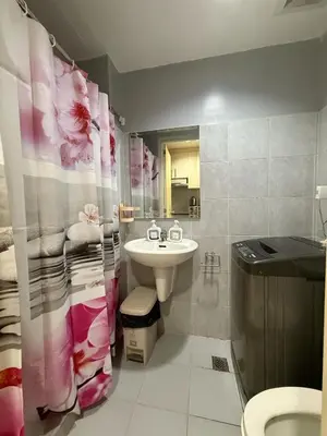 a bathroom with a sink and a shower curtain at Sea Residences Briella's Staycation in Manila