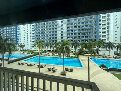 a view of a swimming pool with a large building at Sea Residences Briella's Staycation in Manila