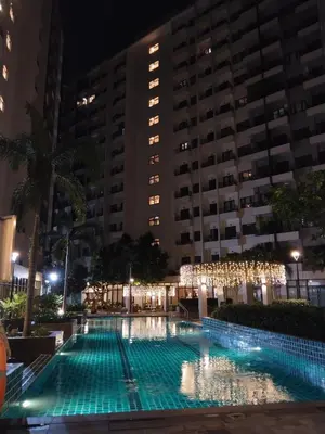 a large swimming pool at night with buildings at Dhayz Staycation in Manila