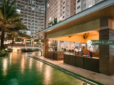 a pool in the middle of a city at night at Shore Residences 2 Bedroom Near NAIA Airport and MOA in Manila