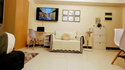 a living room with a chair and a desk at J&M Cozy Retreat - McKinley Hill, BGC in Manila