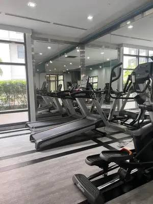 a gym with several treadmills and elliptical machines at J&M Cozy Retreat - McKinley Hill, BGC in Manila