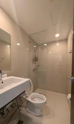 a bathroom with a toilet and a sink and a shower at J&M Cozy Retreat - McKinley Hill, BGC in Manila
