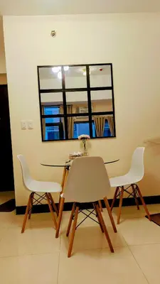 a dining room table with two chairs and a mirror at J&M Cozy Retreat - McKinley Hill, BGC in Manila