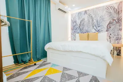 a bedroom with a bed and a blue curtain at Love, Lourdes Villa in Imus