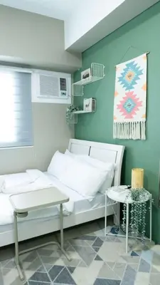 a bedroom with a white bed and a table at The Beacon Condo T2-Studio in Manila
