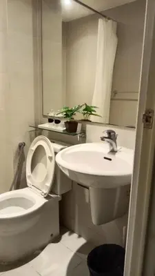 a white bathroom with a toilet and a sink at Casa Crisav Staycation place at AZURE in Manila