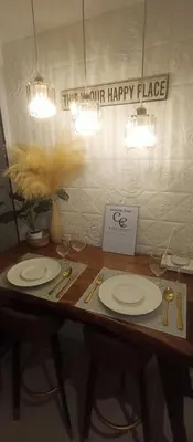 a wooden table with two plates and a happy place sign at Casa Crisav Staycation place at AZURE in Manila