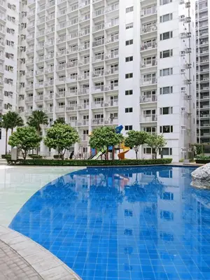 a large swimming pool in front of a large apartment building at Francheska Suite near Mall of Asia in Manila