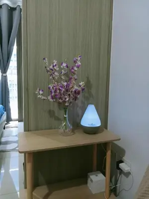 a vase of purple flowers sitting on a table at Francheska Suite near Mall of Asia in Manila