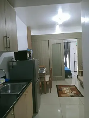 a small kitchen with a sink and a refrigerator at Francheska Suite near Mall of Asia in Manila