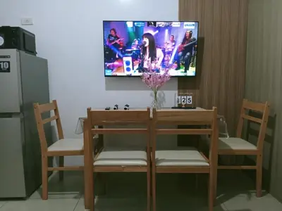 a table and two chairs with a tv on the wall at Francheska Suite near Mall of Asia in Manila