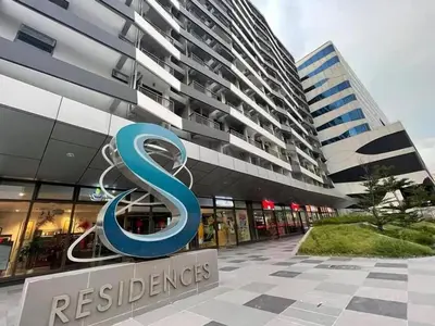 a large building with a s sign in front of it at Gorgeous 1BR Condo Unit near MOA and Manila Int'l Airport in Manila