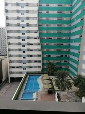 a large building with a swimming pool in front of it at Gorgeous 1BR Condo Unit near MOA and Manila Int'l Airport in Manila
