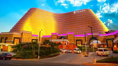 a hotel with a large building with cars parked in a parking lot at Gorgeous 1BR Condo Unit near MOA and Manila Int'l Airport in Manila