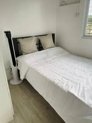 a white bed in a room with a television at AA Cozy Comfort in Nuvali in Calamba