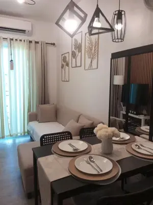 a living room with a table and a couch at AA Cozy Comfort in Nuvali in Calamba