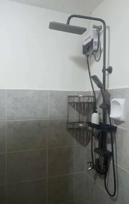 a shower with a blow dryer in a bathroom at AA Cozy Comfort in Nuvali in Calamba