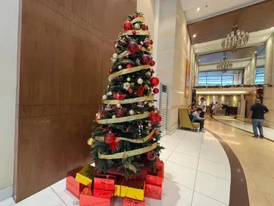 a christmas tree with presents under it in a mall at Grand Riviera Suites 1202 front of US Embassy by Prime Stay in Manila