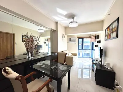 a living room with a table and chairs in a room at Grand Riviera Suites 1202 front of US Embassy by Prime Stay in Manila