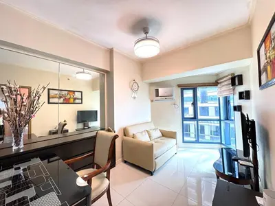 a living room with a couch and a table and a chair at Grand Riviera Suites 1202 front of US Embassy by Prime Stay in Manila
