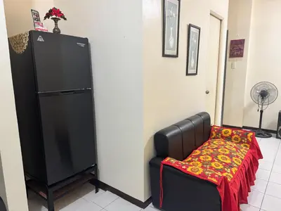 a black refrigerator and a chair with a red blanket at Las Asturias in Balibago