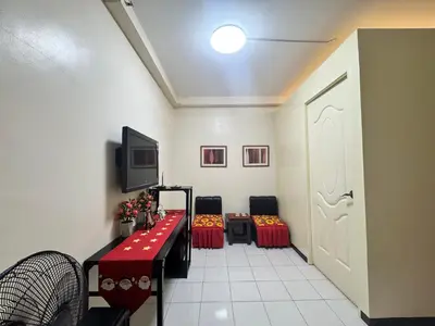 a waiting room with a table and chairs and a tv at Las Asturias in Balibago