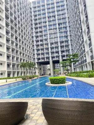 a large apartment building with a large swimming pool at Cozy Vibes near MOA & NAIA AIRPORT with NETFLIX,MINIVIDEOKE,BOARDGAMES-DUXE6 in Manila