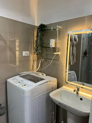 a bathroom with a washing machine and a sink at Cozy Vibes near MOA & NAIA AIRPORT with NETFLIX,MINIVIDEOKE,BOARDGAMES-DUXE6 in Manila