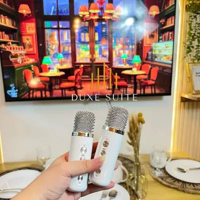 a person holding two microphones in front of a table at Cozy Vibes near MOA & NAIA AIRPORT with NETFLIX,MINIVIDEOKE,BOARDGAMES-DUXE6 in Manila