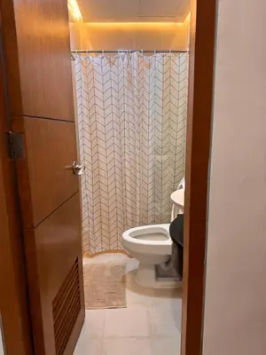 a bathroom with a toilet and a shower curtain at Morgan Suites Executive Residences 2 in Manila