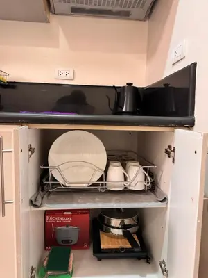 a cabinet filled with dishes and utensils at Morgan Suites Executive Residences 2 in Manila
