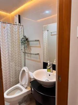 a bathroom with a white toilet and a sink at Morgan Suites Executive Residences 2 in Manila