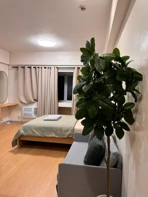 a bedroom with a bed and a potted plant at Morgan Suites Executive Residences 3 in Manila